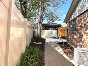 View of yard featuring central AC, a gazebo, a patio area, and a fenced backyard