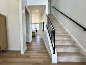 Staircase featuring recessed lighting, wood finished floors, and baseboards