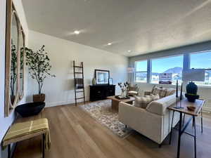 Living area featuring recessed lighting, a textured ceiling, wood finished floors, and baseboards