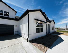 View of home's exterior featuring a garage, board and batten siding, and concrete driveway