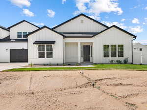Modern inspired farmhouse with board and batten siding, concrete driveway, and a garage