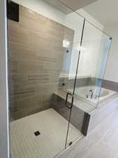 Full bathroom featuring a bath and a stall shower