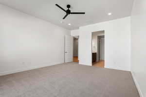 Unfurnished bedroom featuring light colored carpet, recessed lighting, ensuite bathroom, and a ceiling fan