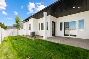 Rear view of property featuring stucco siding, a fenced backyard, and a patio