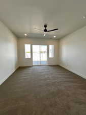 Unfurnished room featuring baseboards, recessed lighting, dark carpet, and ceiling fan