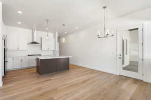Kitchen featuring light countertops, a chandelier, light wood-type flooring, white cabinetry, and recessed lighting