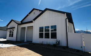 View of front of house with fence and board and batten siding