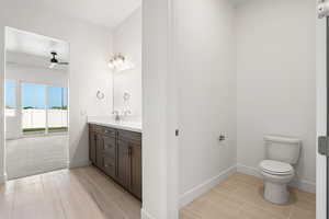 Bathroom featuring vanity, a ceiling fan, and wood finish floors
