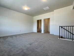 Carpeted empty room featuring baseboards