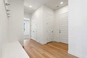 Foyer with light wood-style floors and recessed lighting