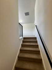 Stairs featuring baseboards, visible vents, and carpet floors