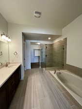 Full bath with a bath, visible vents, a shower stall, and vanity
