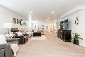 Living area with recessed lighting, baseboards, and carpet floors