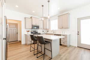 Kitchen with tasteful backsplash, a kitchen breakfast bar, appliances with stainless steel finishes, and a sink