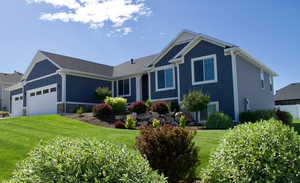 View of front of property featuring board and batten siding, a front yard, and an attached garage