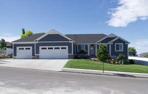 View of front of house with fence, driveway, a front yard, and a garage