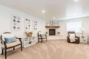 Sitting room with baseboards, recessed lighting, carpet floors, and a glass covered fireplace