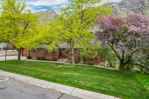 View of front of home with a mountain view and a front yard