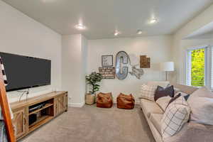 Living room with baseboards, recessed lighting, and light carpet