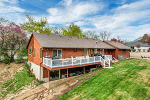 Back of house with a lawn, a wooden deck, central AC, and roof with shingles
