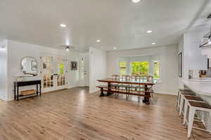 Dining area featuring baseboards, french doors, and light wood-style floors
