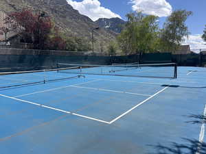 View of sport court featuring fence and a mountain view