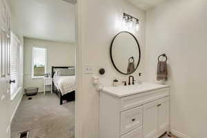Bathroom with visible vents, vanity, ensuite bathroom, and baseboards