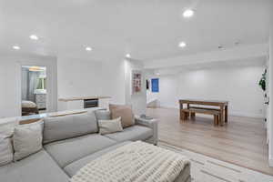 Living area with dry bar, recessed lighting, light wood finished floors, and baseboards