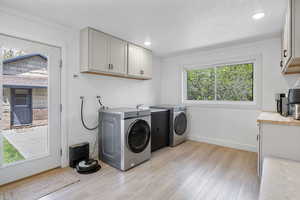 Washroom with light wood finished floors, recessed lighting, cabinet space, sink, washer and clothes dryer, and baseboards