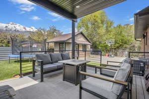 View of patio / terrace featuring fence, a mountain view, an outdoor living space, and a trampoline