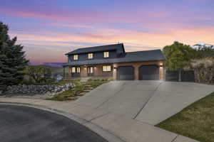 View of front of home with a garage, brick siding, a porch, and driveway