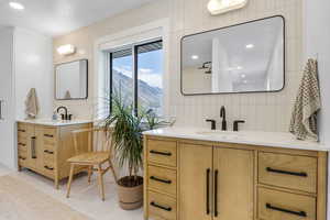 Bathroom with two vanities, a sink, and tasteful backsplash