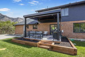 Back of property with a patio, a garden, brick siding, and a mountain view