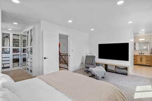 Bedroom with baseboards, recessed lighting, and ensuite bath