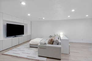 Living area with recessed lighting, baseboards, and light wood-style floors