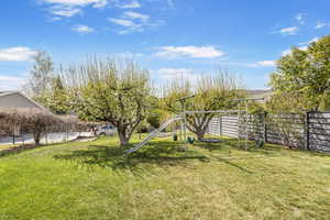 View of yard with fence and a playground