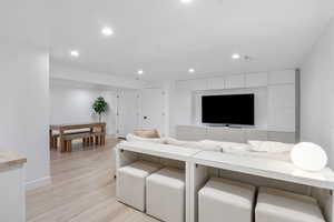 Living area featuring baseboards, recessed lighting, and light wood-style floors