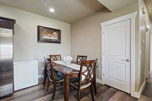 Dining room with dark wood-type flooring, visible vents, recessed lighting, and baseboards. Freezer not included.