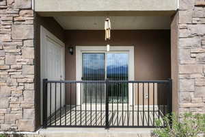 Entrance to property with stone siding and stucco siding