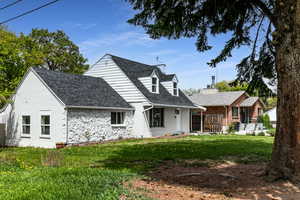 View of front facade featuring roof with shingles, a front yard, and brick siding