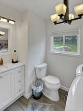 Bathroom/Laundry, wood finished floors, vanity, notable chandelier