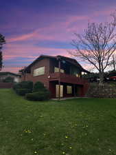 East side of house at dusk, balcony, covered patio.