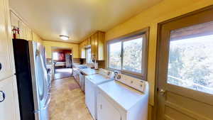 Laundry area with washer and clothes dryer, laundry area, and a sink
