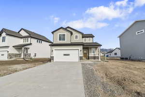 View of front facade with concrete driveway, a shingled roof, brick siding, and a garage *LANDSCAPING COMING SOON*