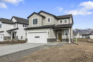 View of front of property with stucco siding, concrete driveway, a mountain view, and a garage *LANDSCAPING COMING SOON*