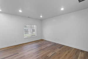 Living room featuring visible large window, recessed lighting, and laminate flooring