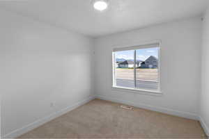 Bedroom featuring visible vents, light colored carpet, and baseboards