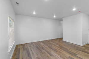 Living room featuring visible large window, recessed lighting, and laminate flooring
