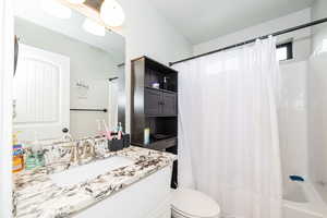 Full bathroom featuring toilet, shower / tub combo, and vanity