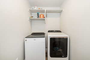 Laundry area featuring washer and clothes dryer and laundry area. Has doors to hide laundry.